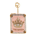 Decorative keychain with crown and 'The Queen' text on a pink background